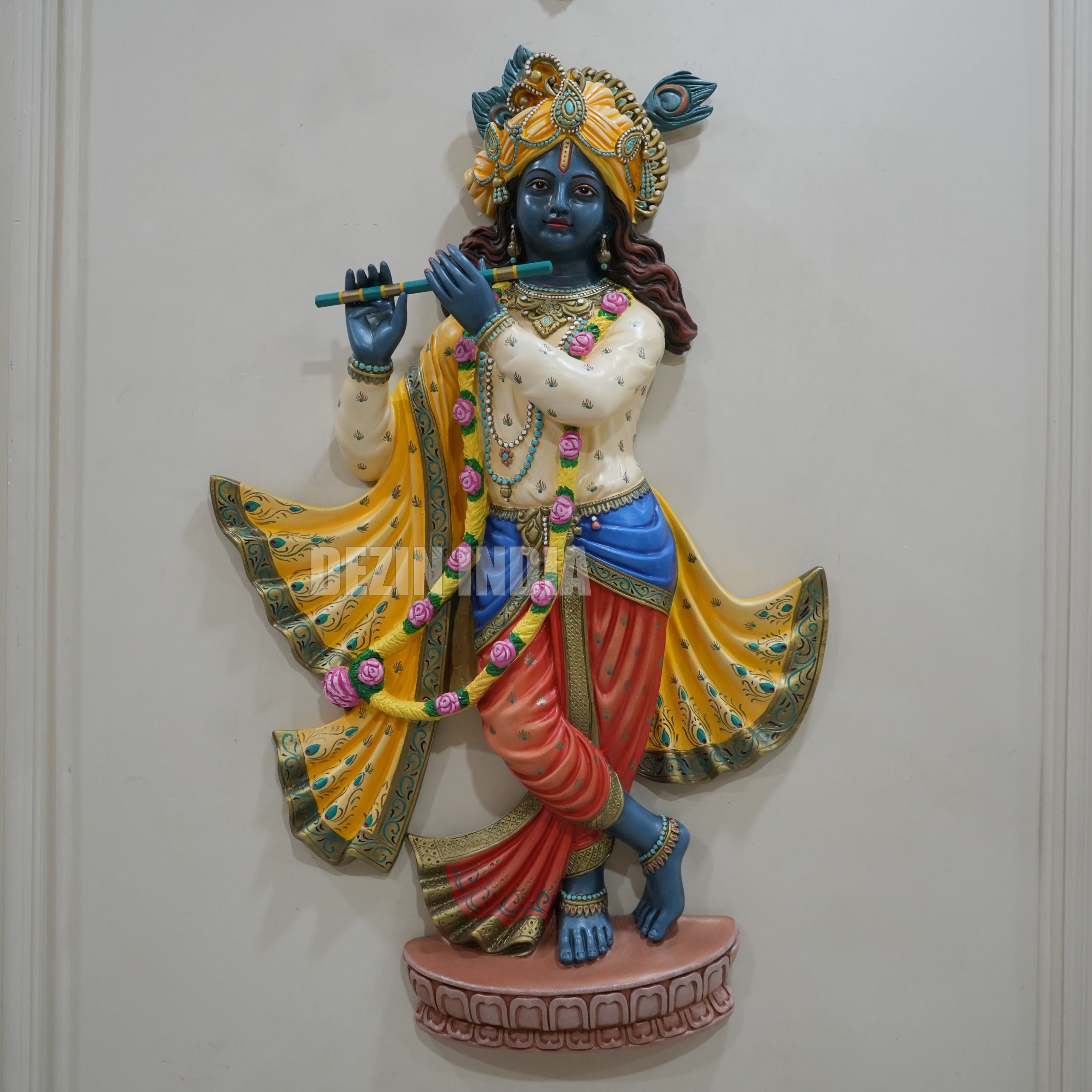 Colorful statue of a deity holding a flute on a white background